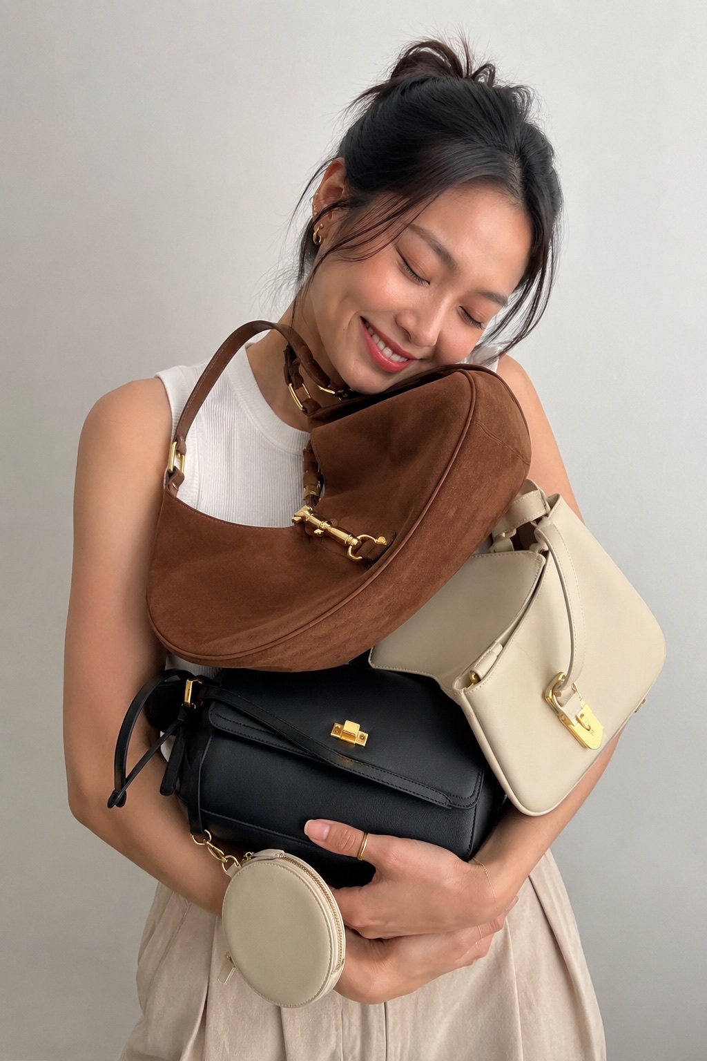 Creator holding a coordinated collection of handbags